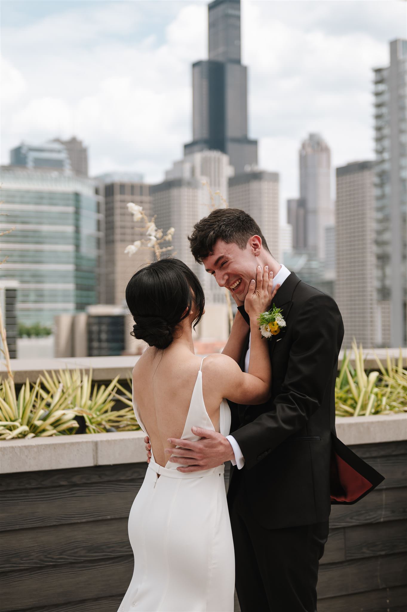 bride and groom seeing each other during their first look on a chicago rooftop