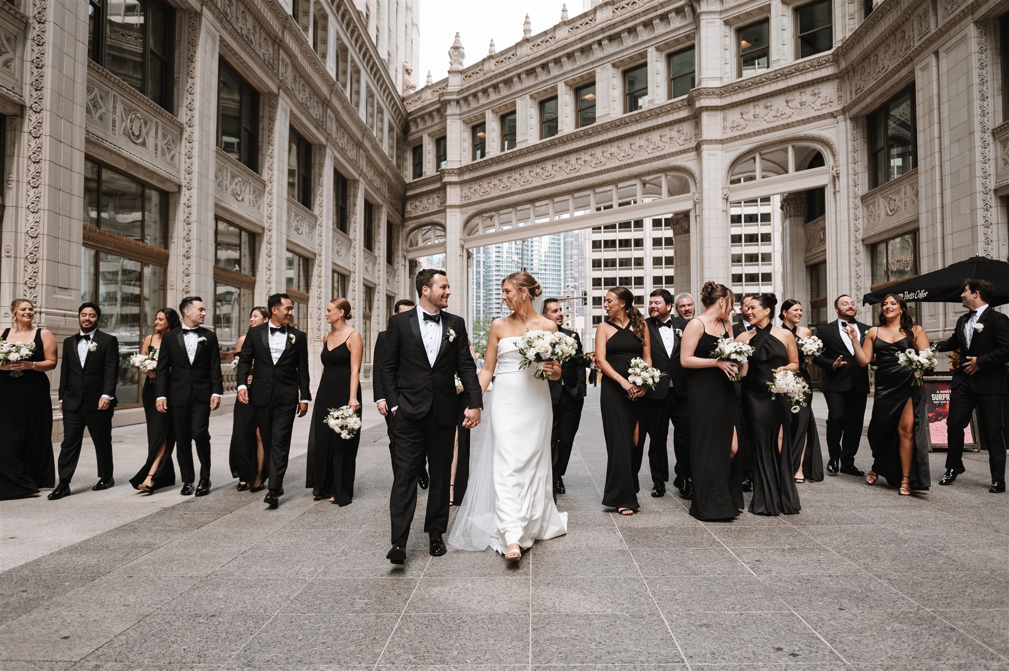 wedding party walking downtown by wrigley building in chicago