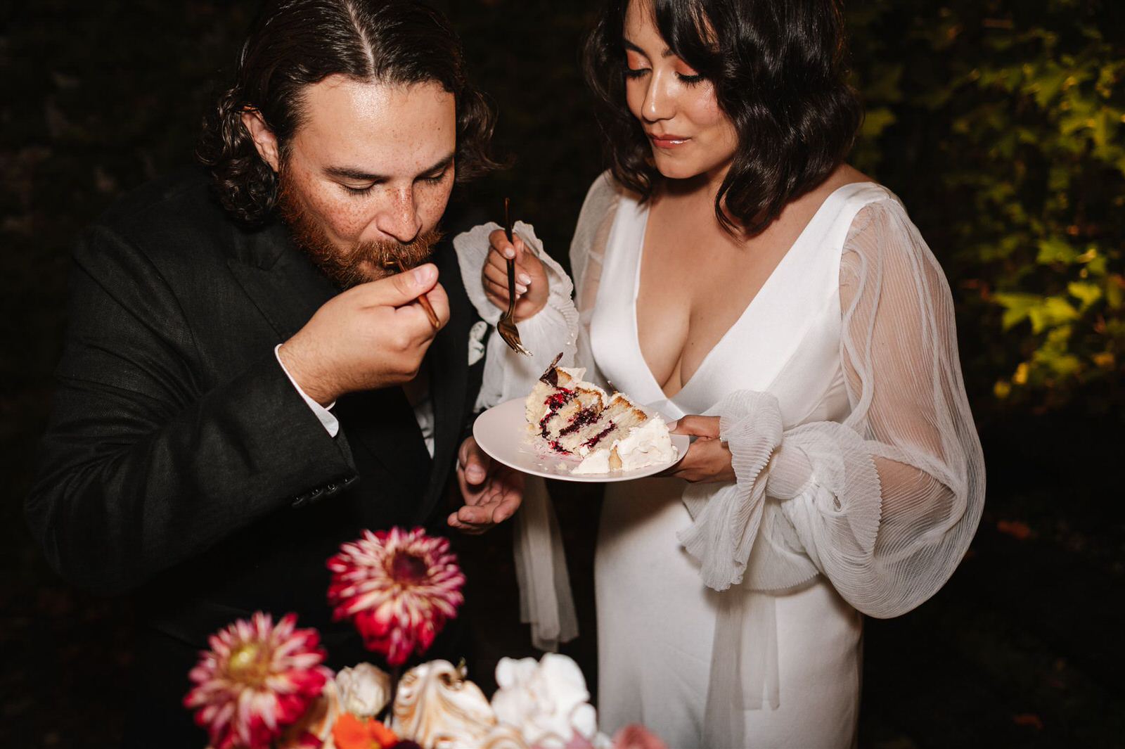 candid moment of bride and groom cutting their cake during their reception