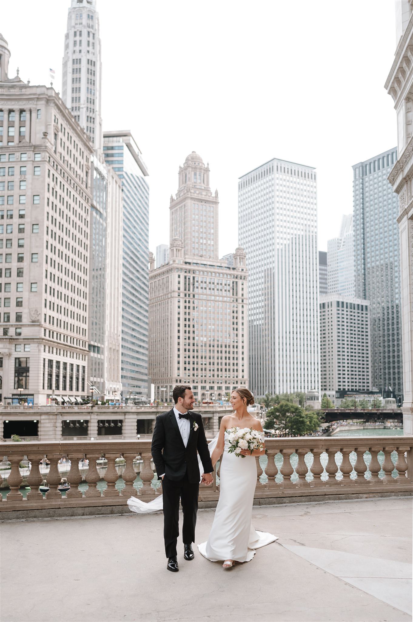 bride and groom candid wedding photography portrait at the wrigley building near the riverwalk in chicago